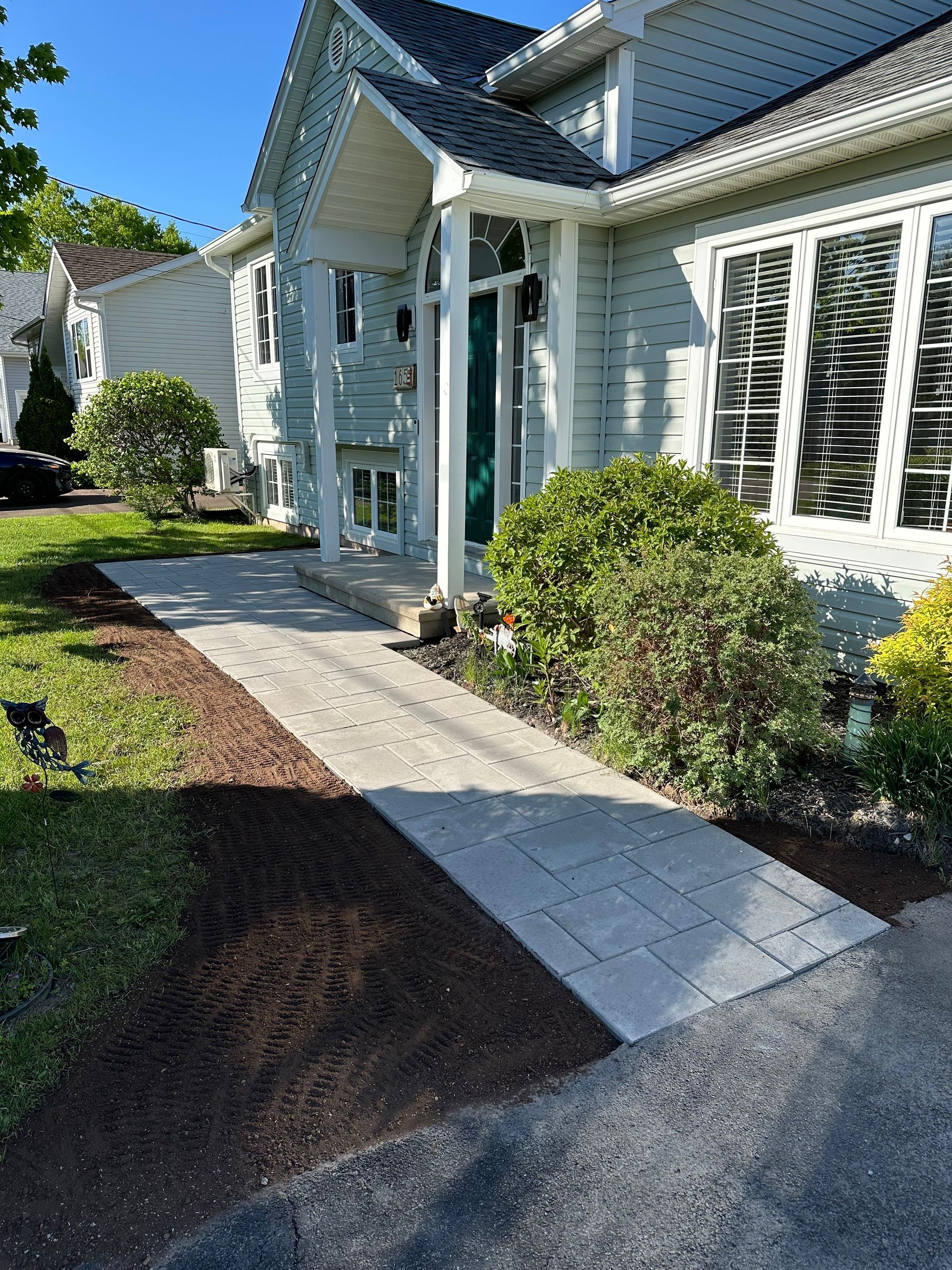 A white house with a walkway leading to the front door.
