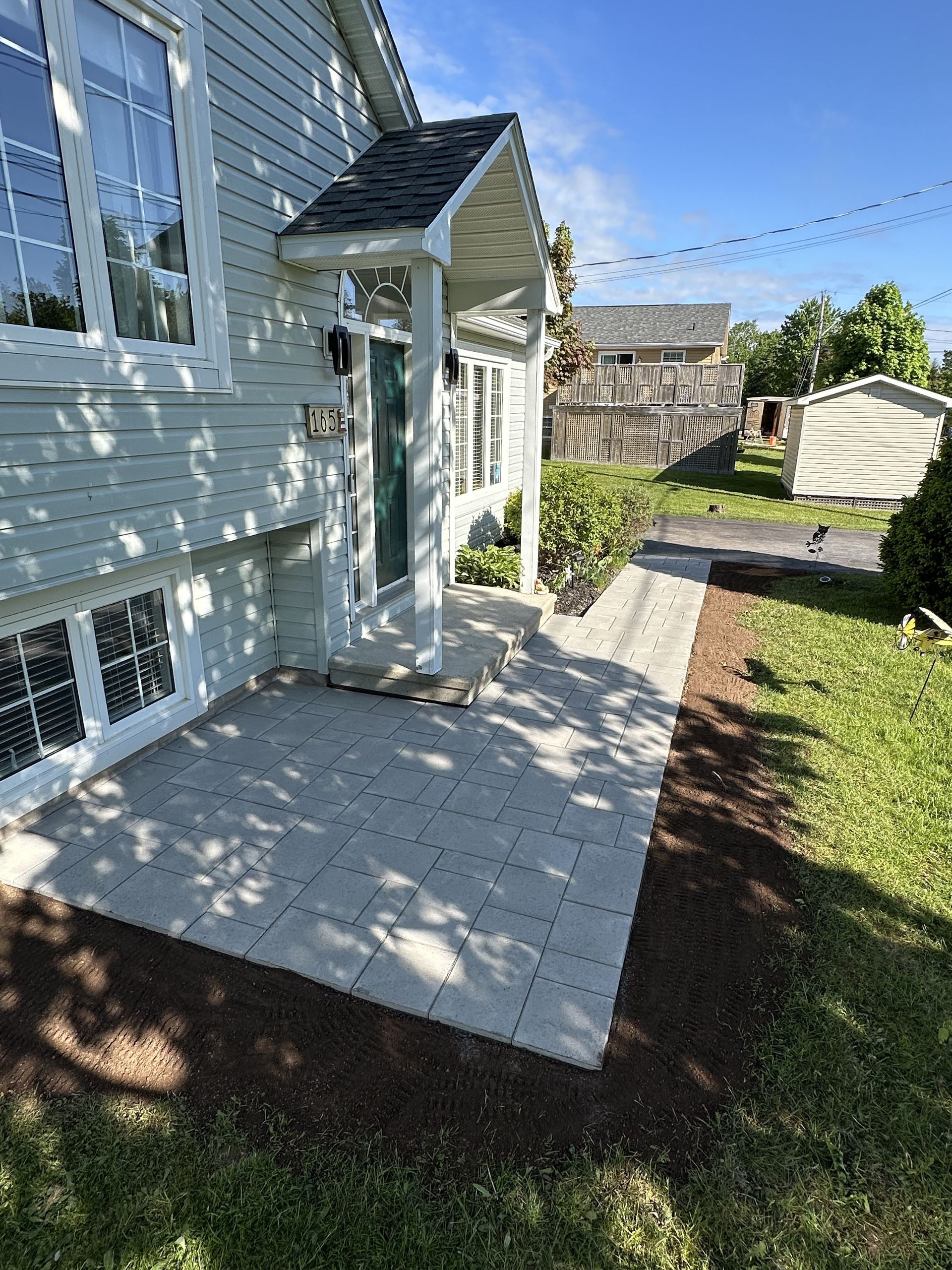 A house with a patio and a walkway in front of it.