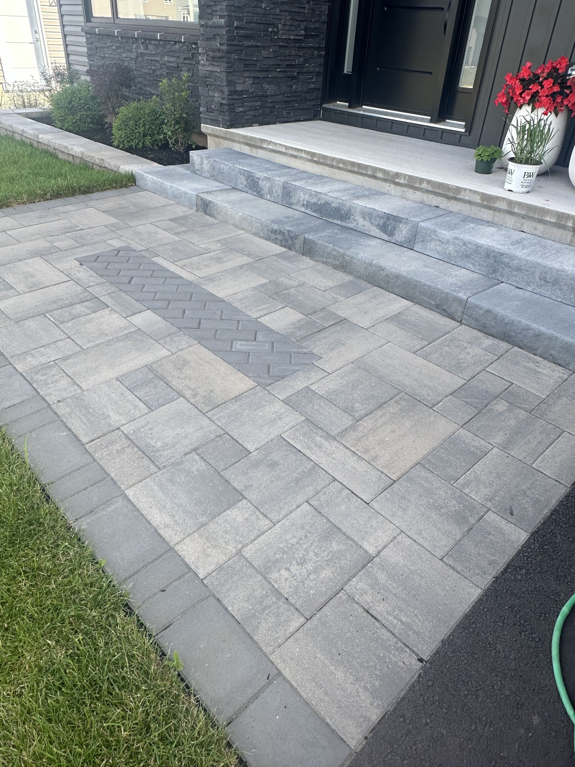 A brick walkway leading to the front door of a house.