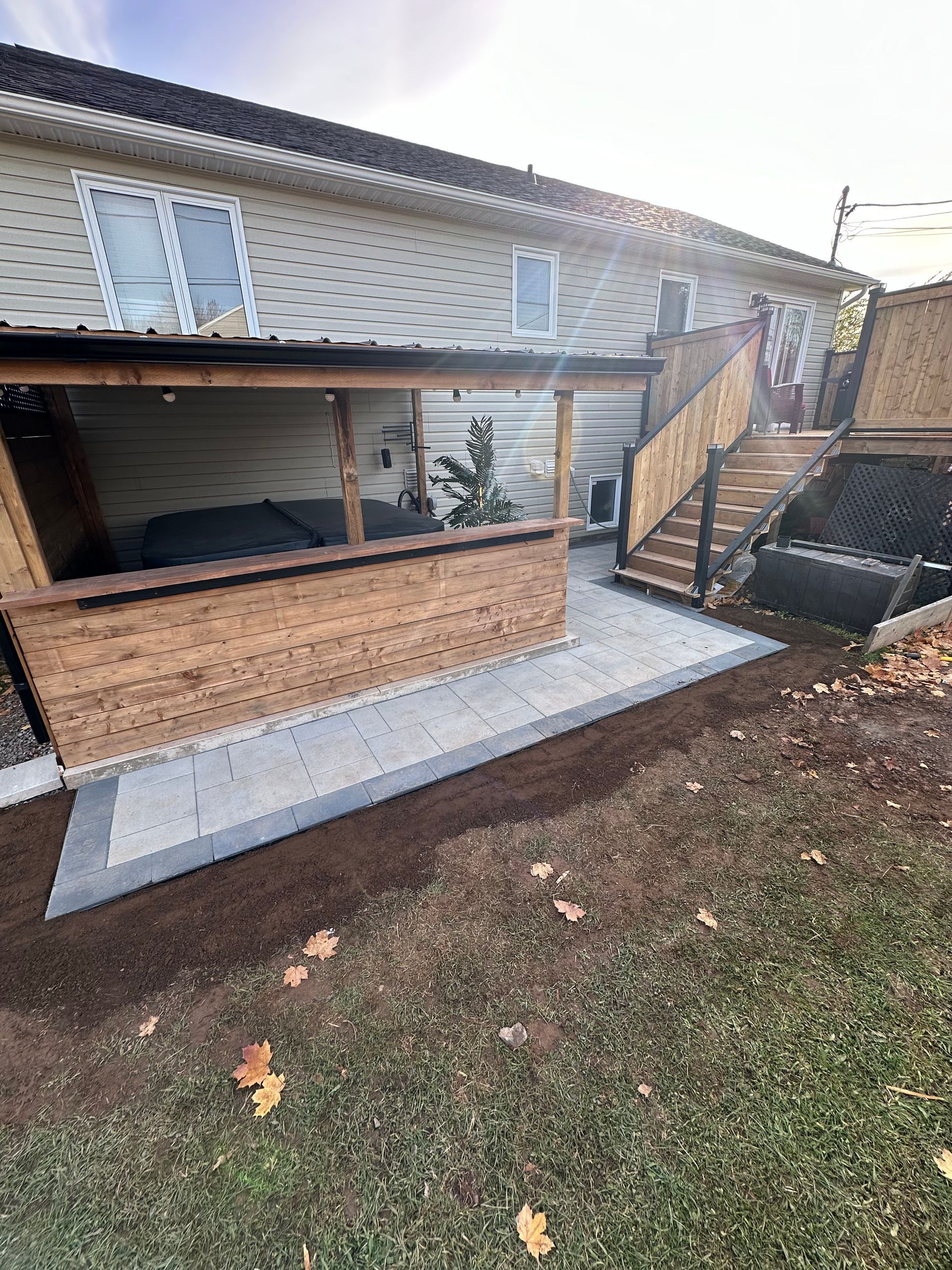 A house with a wooden deck and stairs in the backyard.