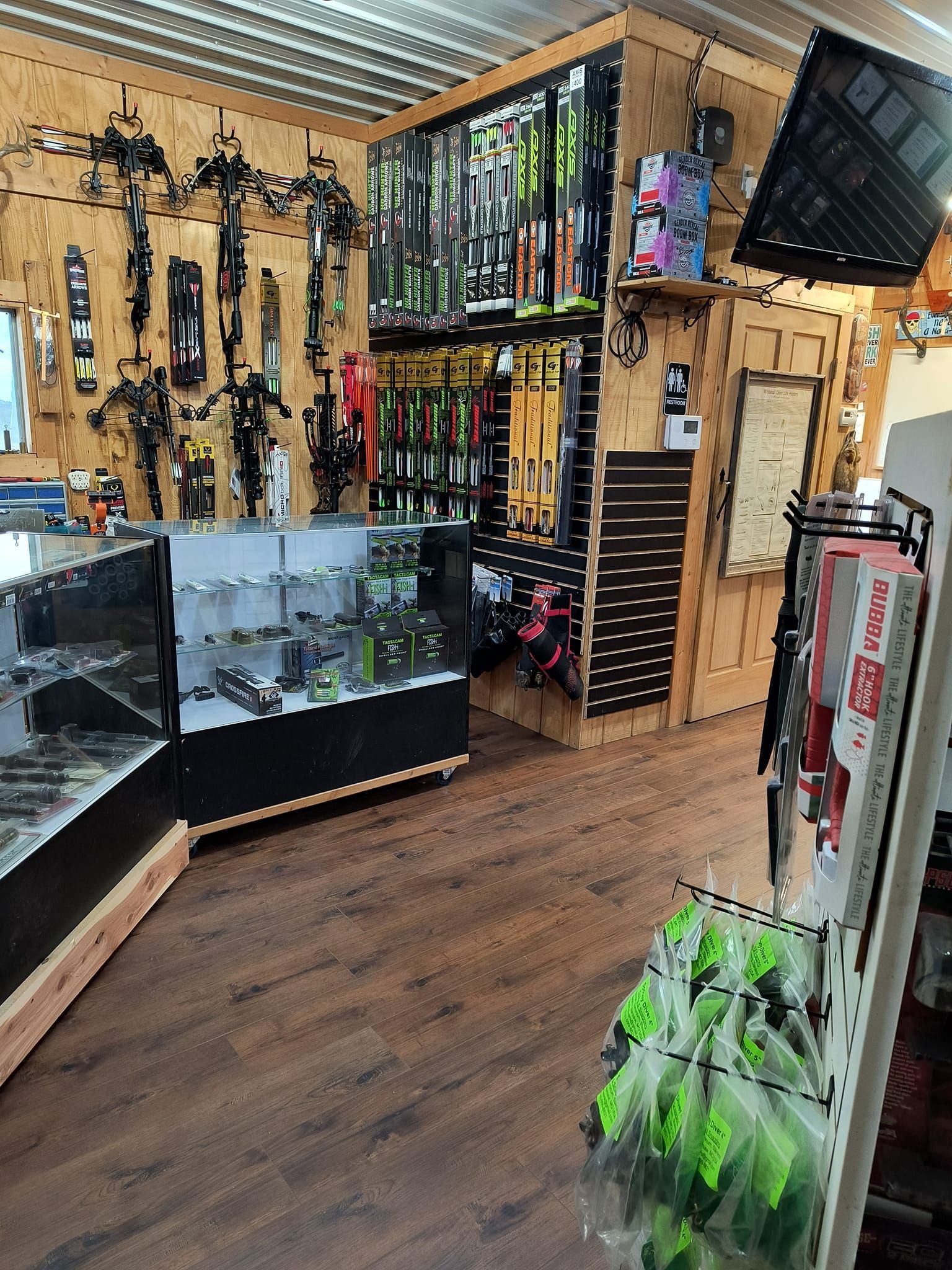 Interior of a sporting goods store, featuring archery equipment, fishing gear, and display cases.