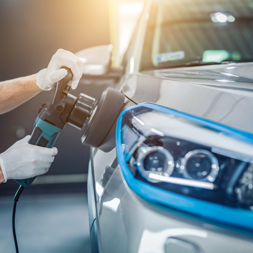 A person is polishing a car with a machine.