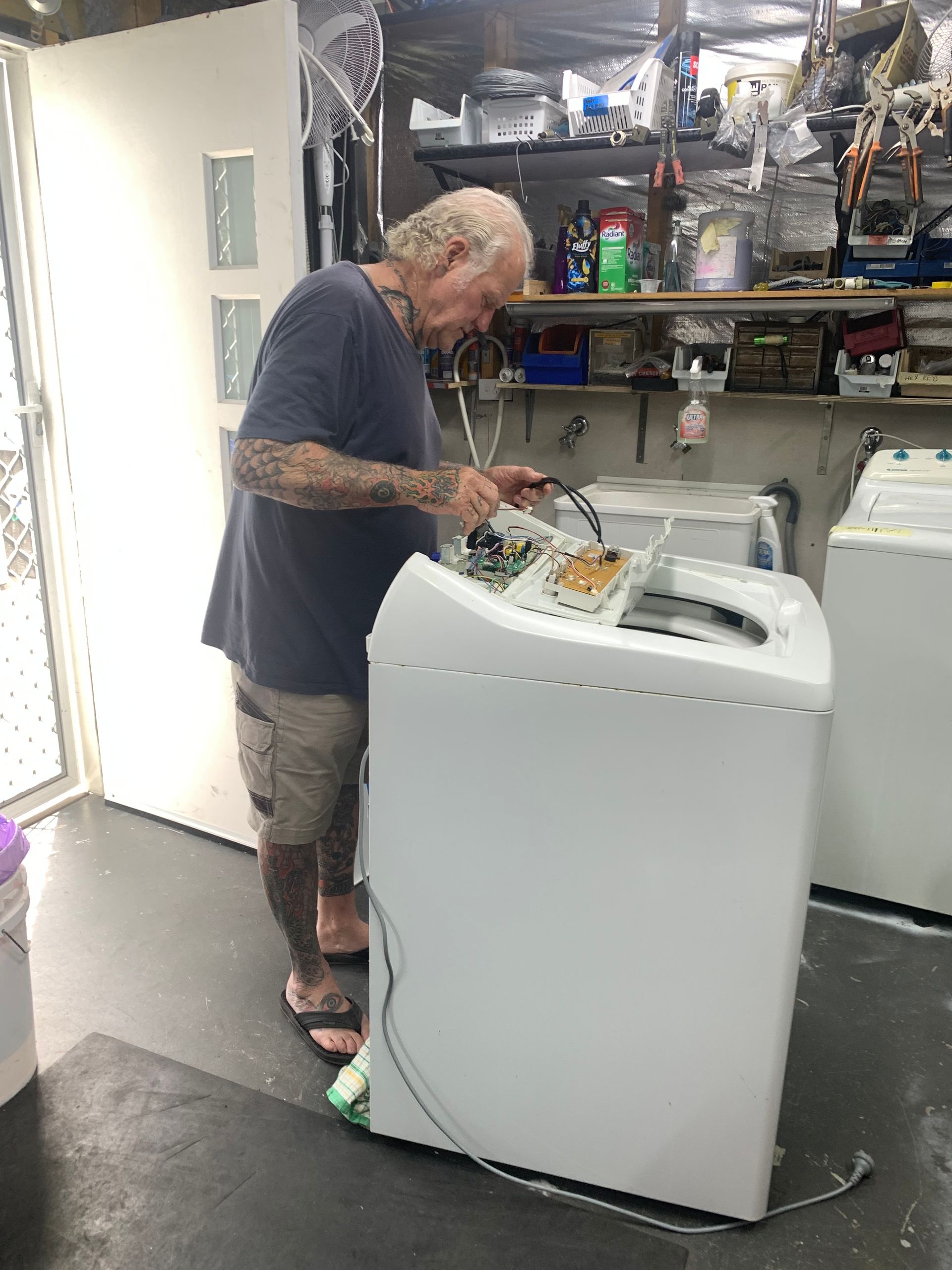 A Man Repairing A Washing Machine — Appliance Repair in The Entrance, NSW