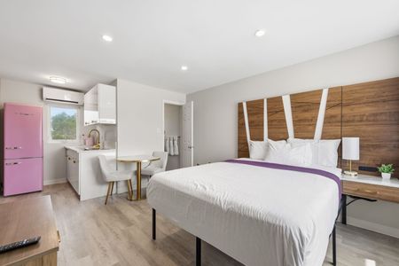 Two beds in a hotel room with peach headboards and light pink bedskirts.