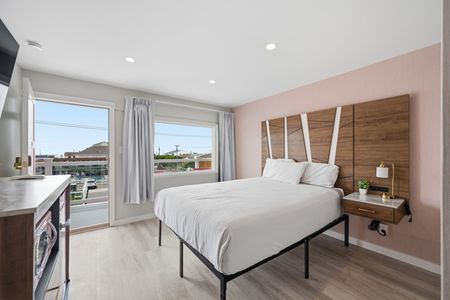 Two beds in a hotel room with peach headboards and light pink bedskirts.