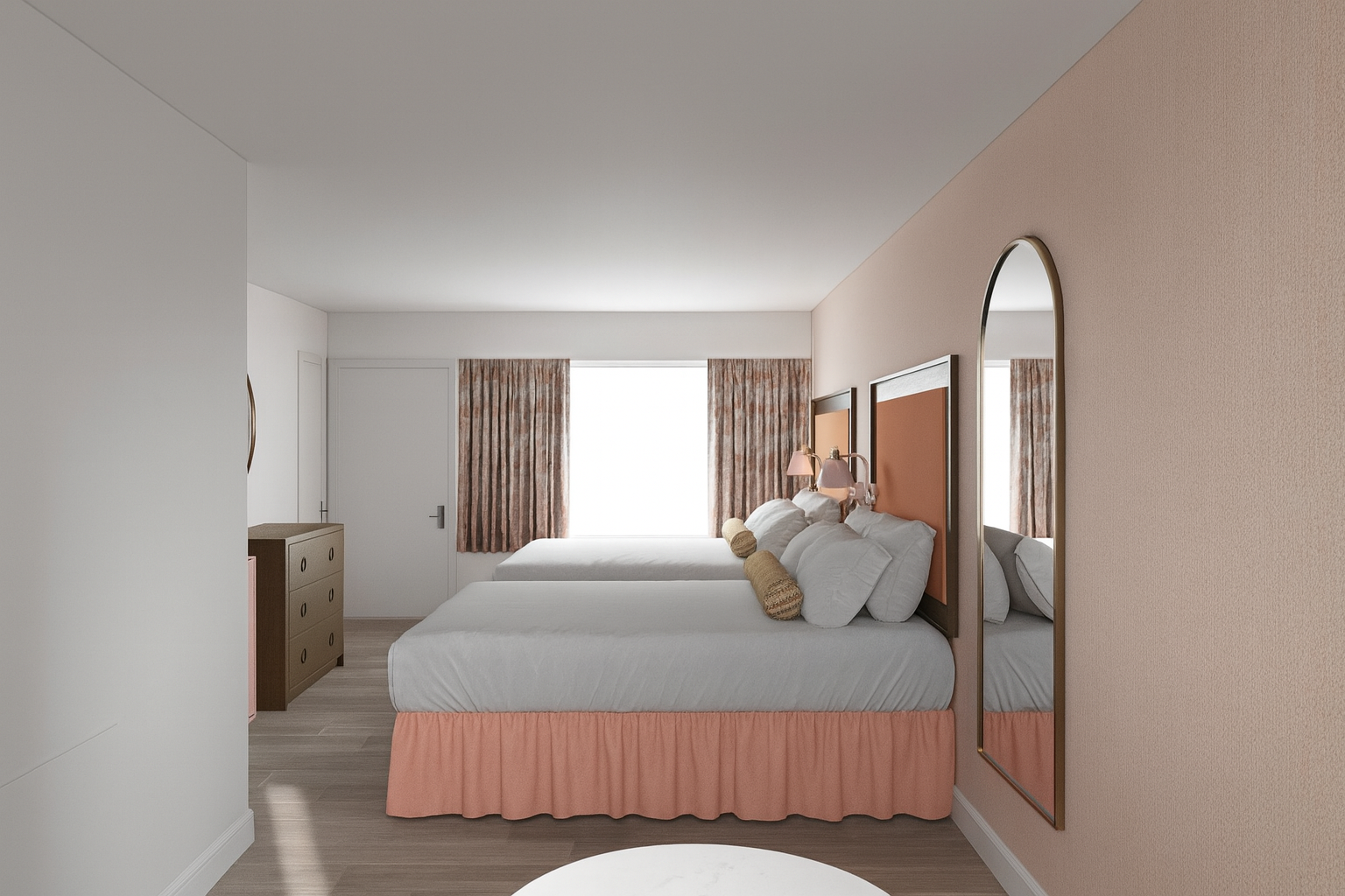 Hotel room with two beds, an arched mirror, and peach-colored accents.