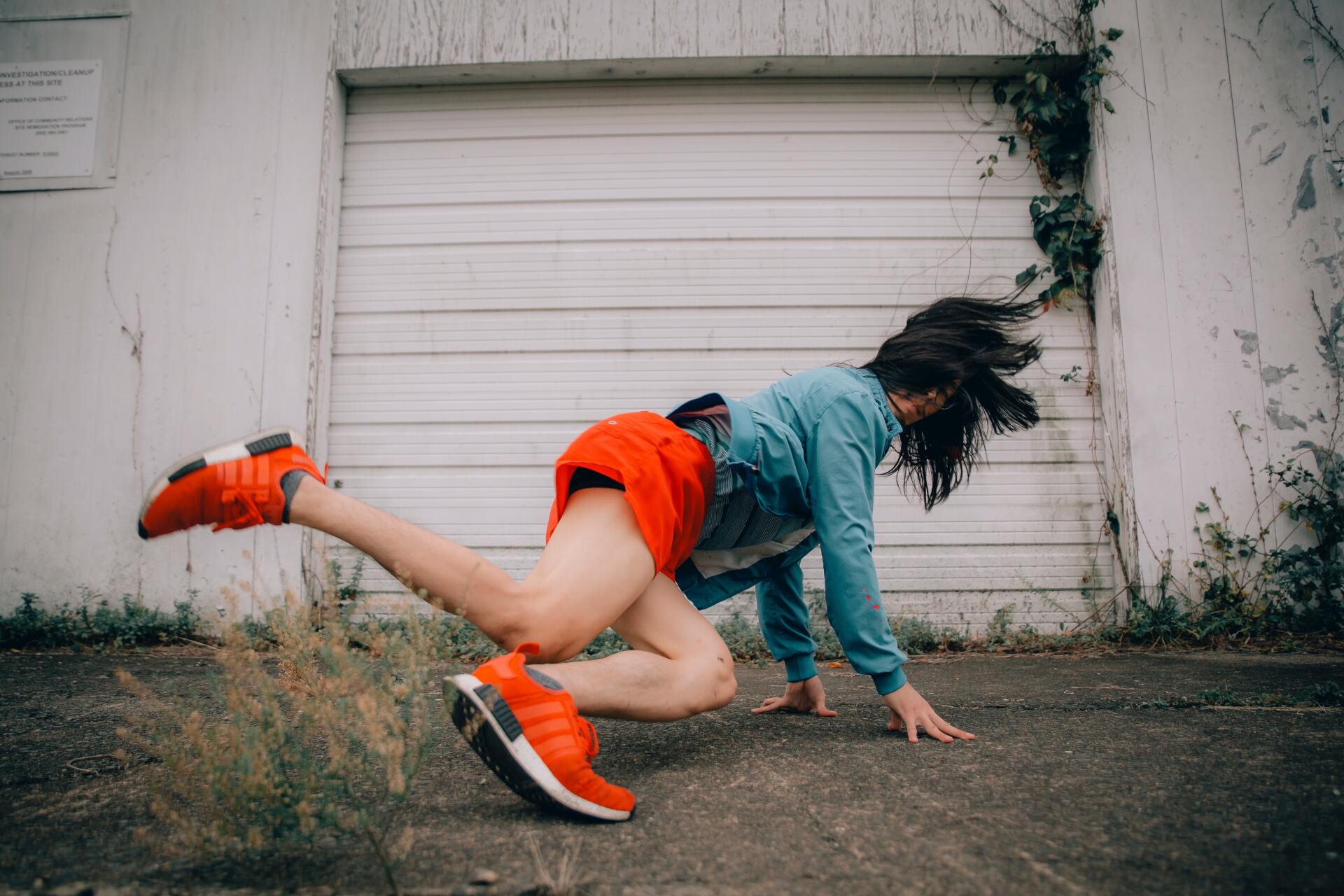 Woman break dancing wearing orange shoes and shorts