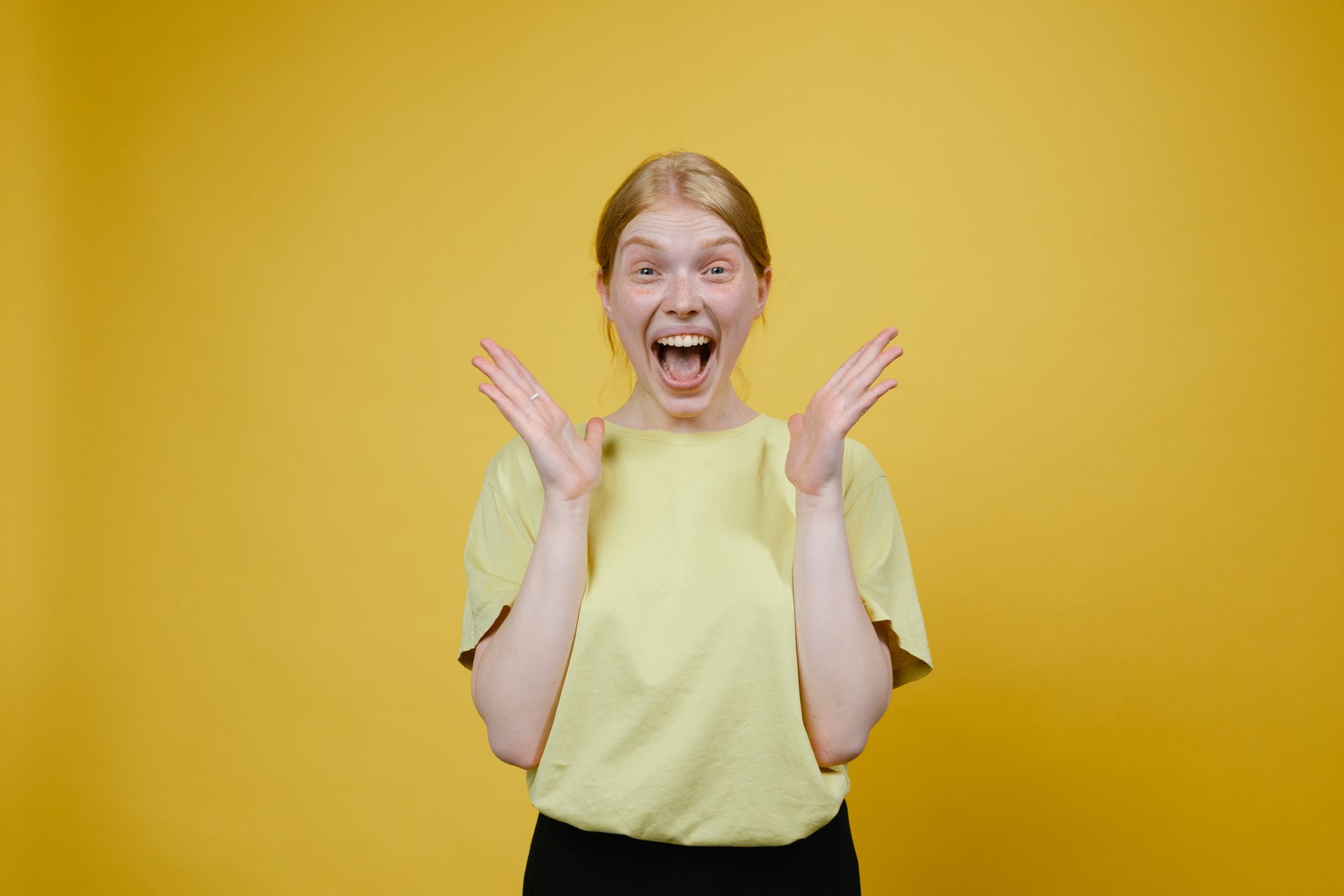 Woman with a wow expression in front of yellow background