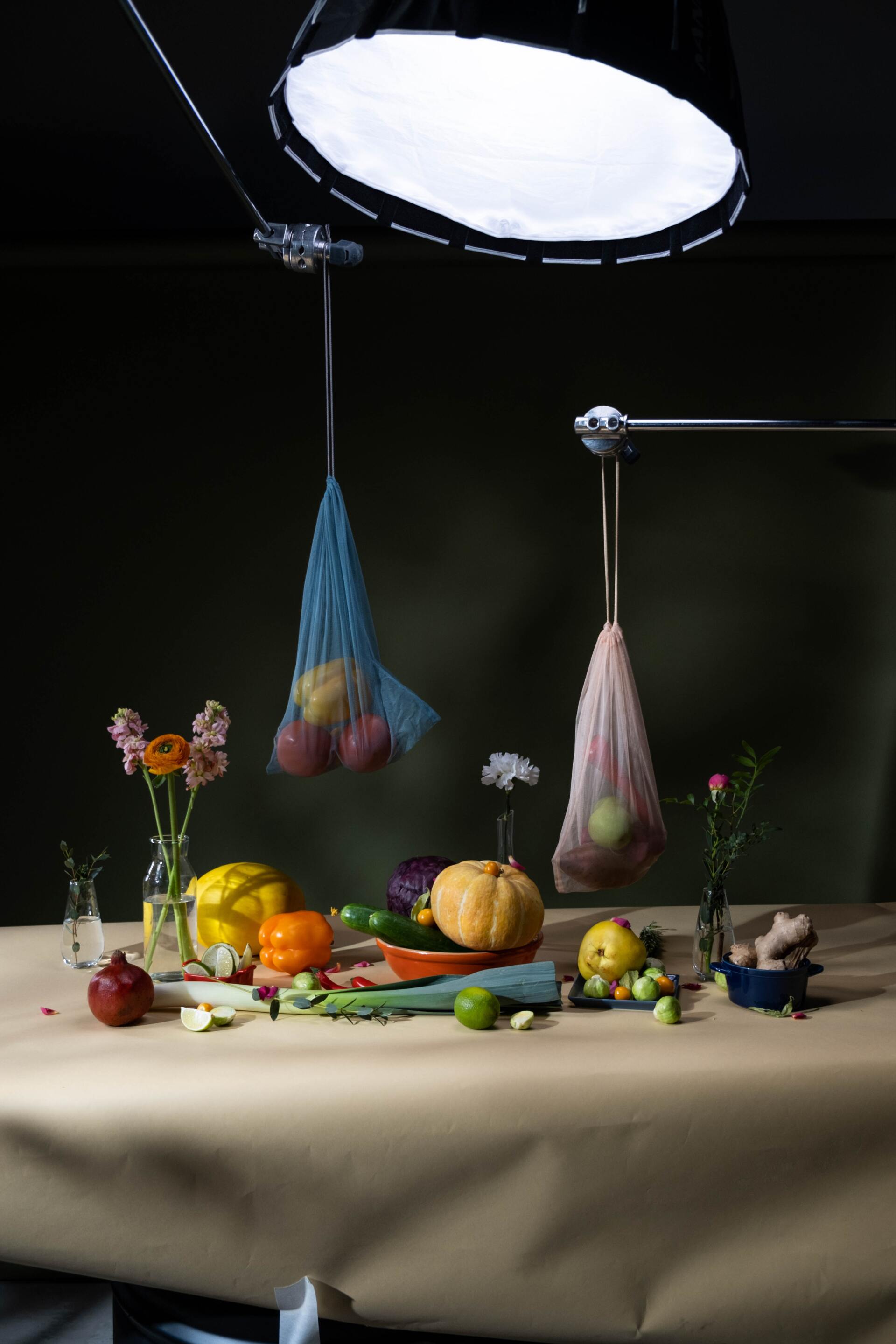 behind the scenes image of a table top studio shoot featuring fruit on table top and hanging fruit bags