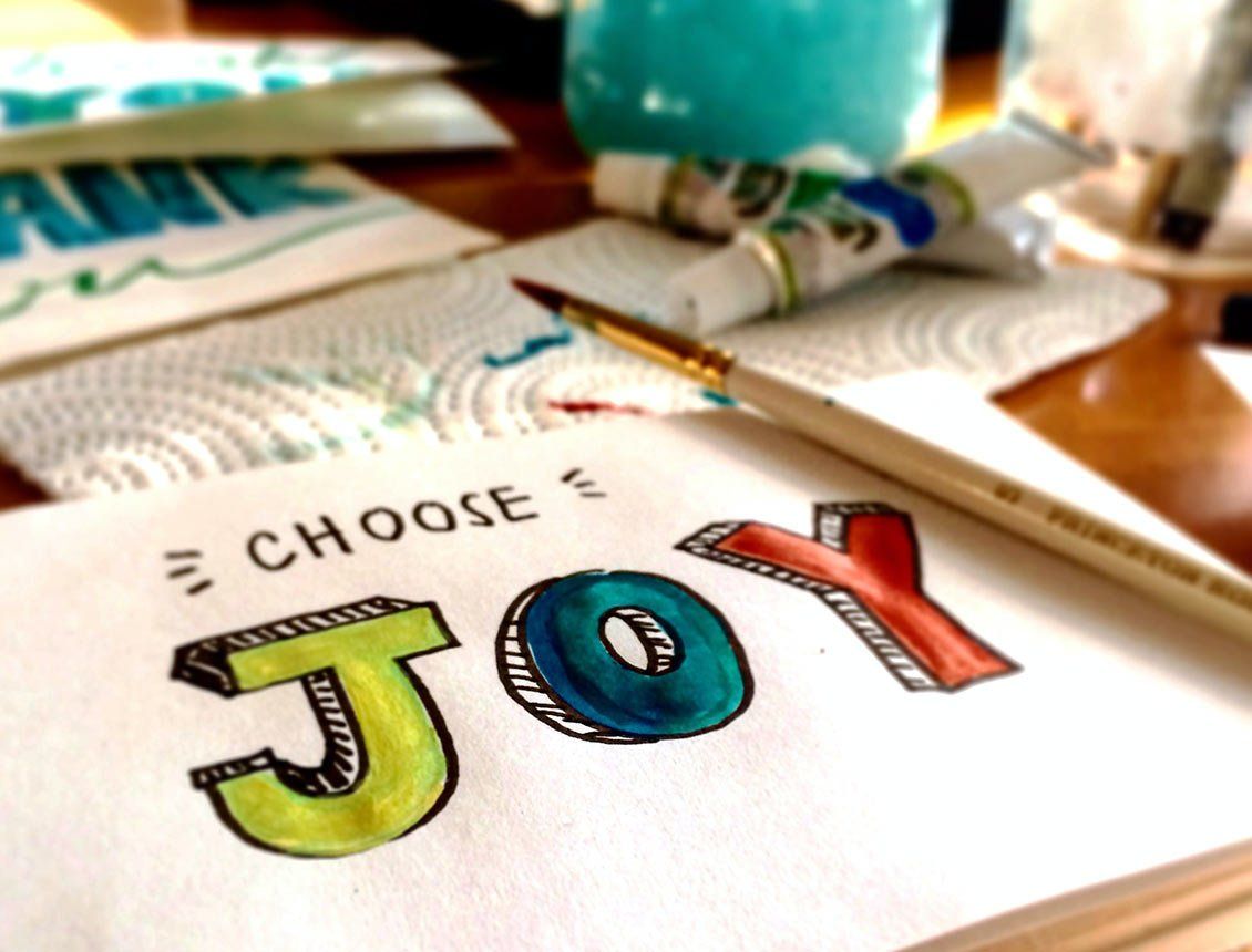 Image of close up the word joy painted on paper
