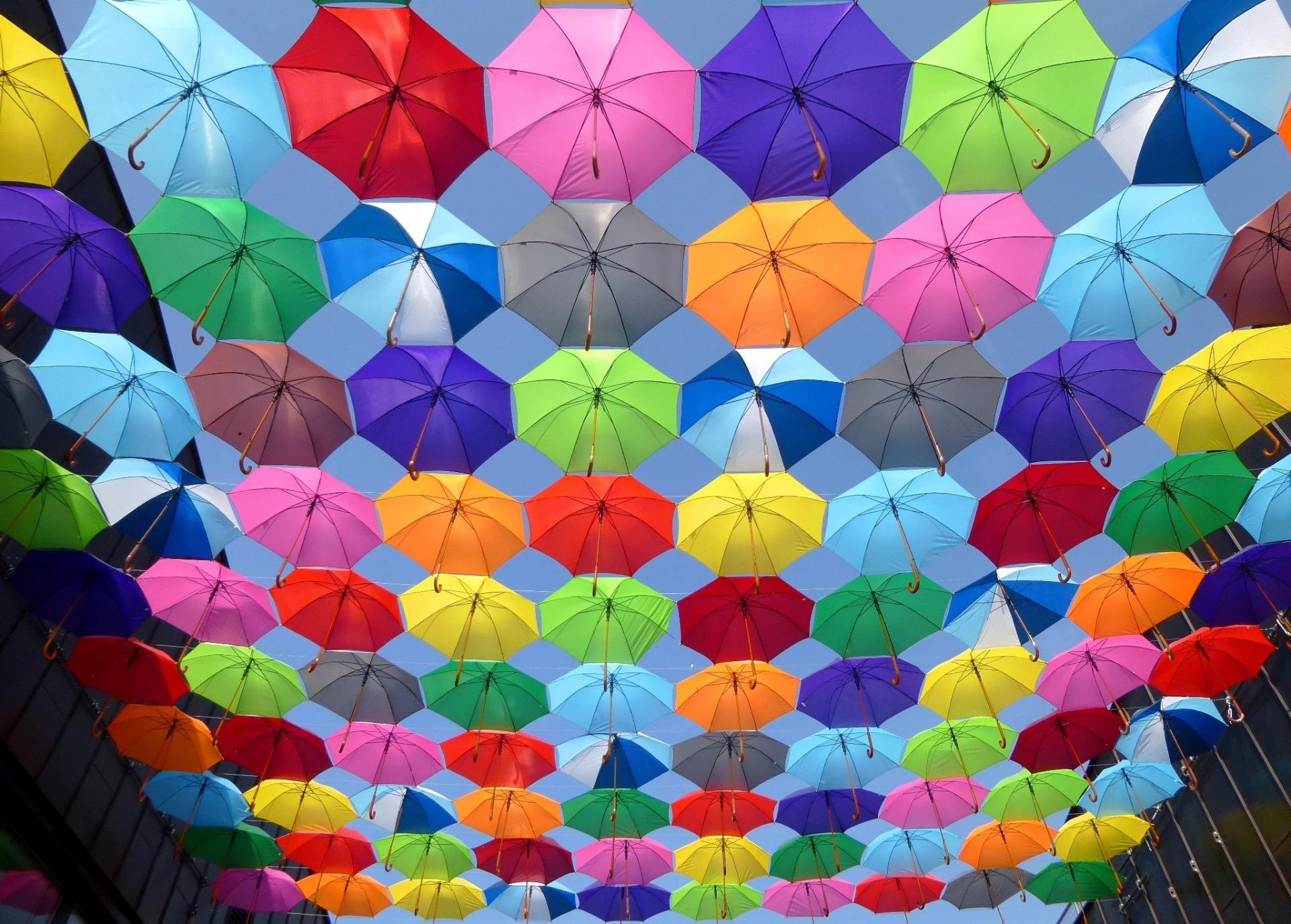 Low wide angle image of multi colored umbrellas grouped together
