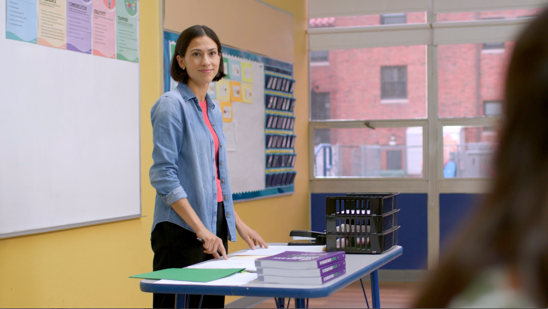 A man is sitting in an office chair looking at his cell phone.