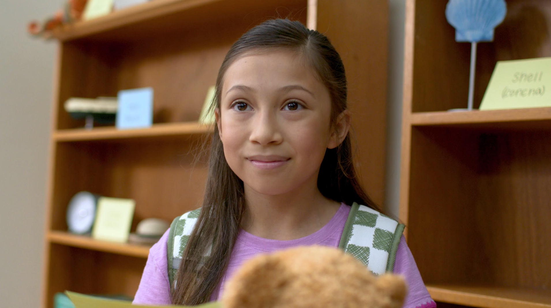 A woman wearing glasses is sitting in front of a laptop computer.