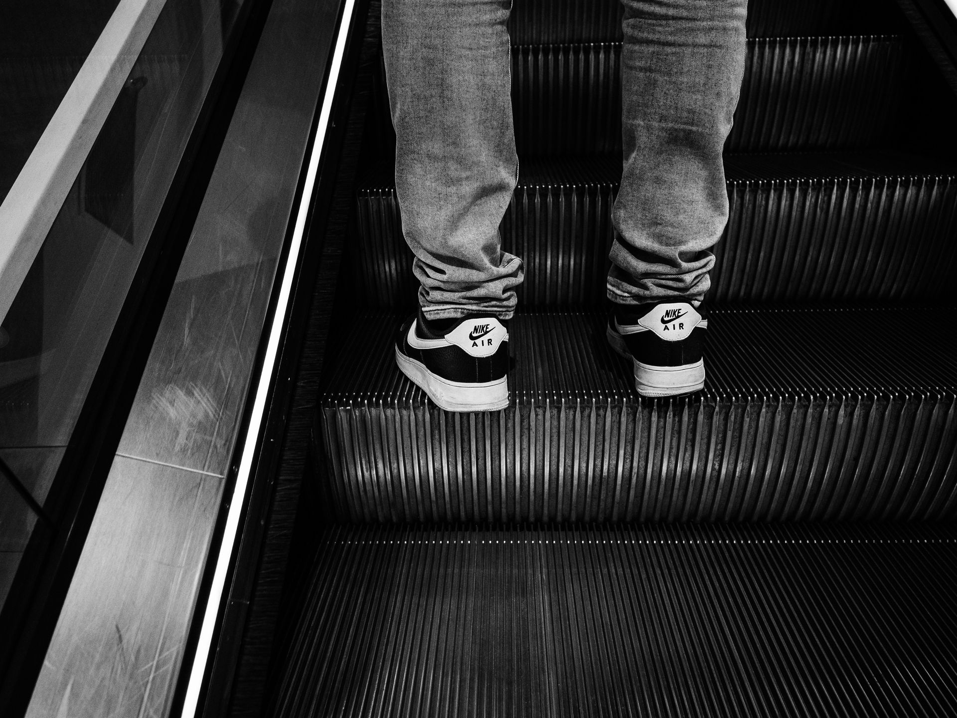 Person wearing Nike shoes on an escalator