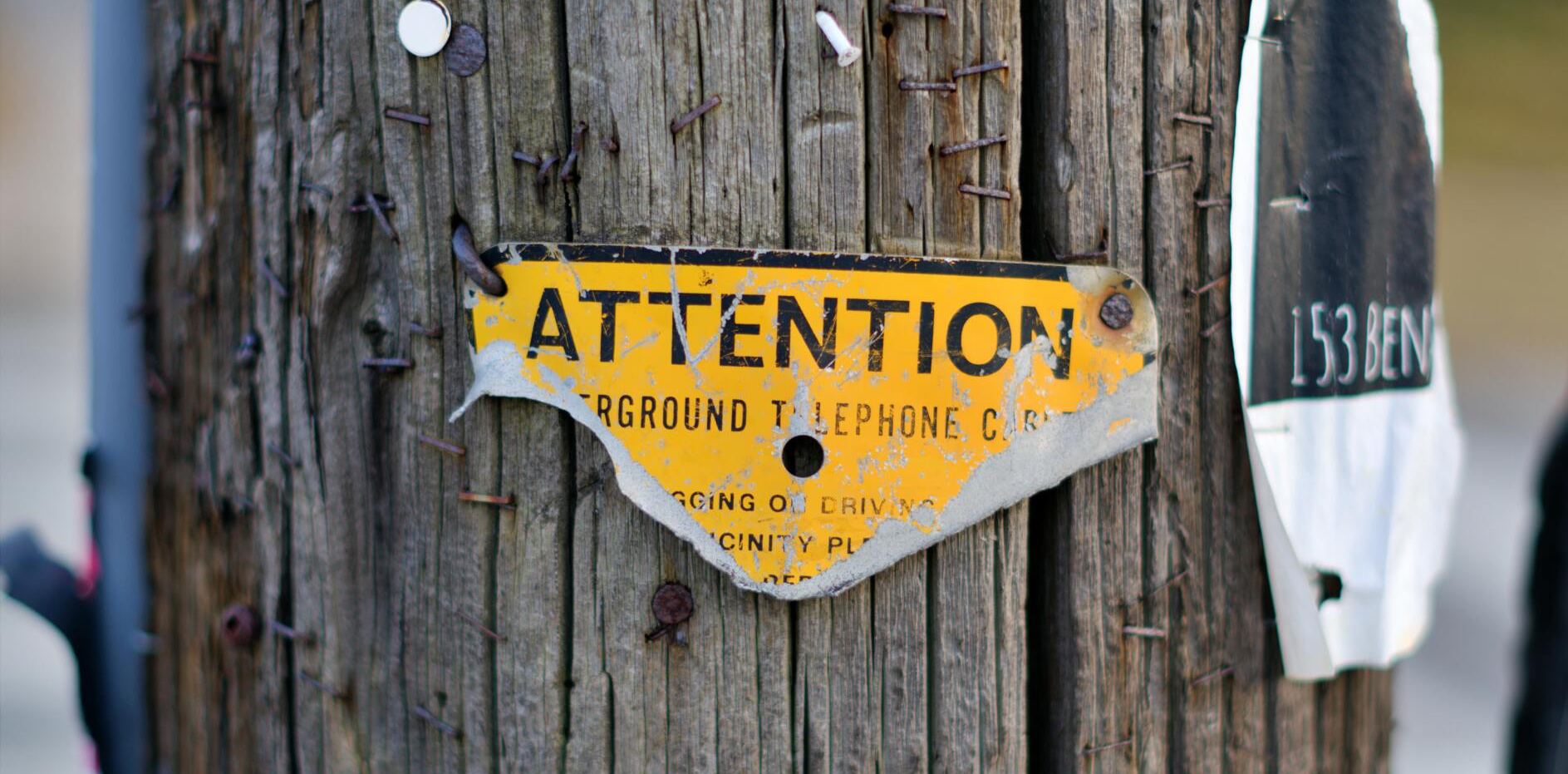 Attention sign in yellow on telephone pole