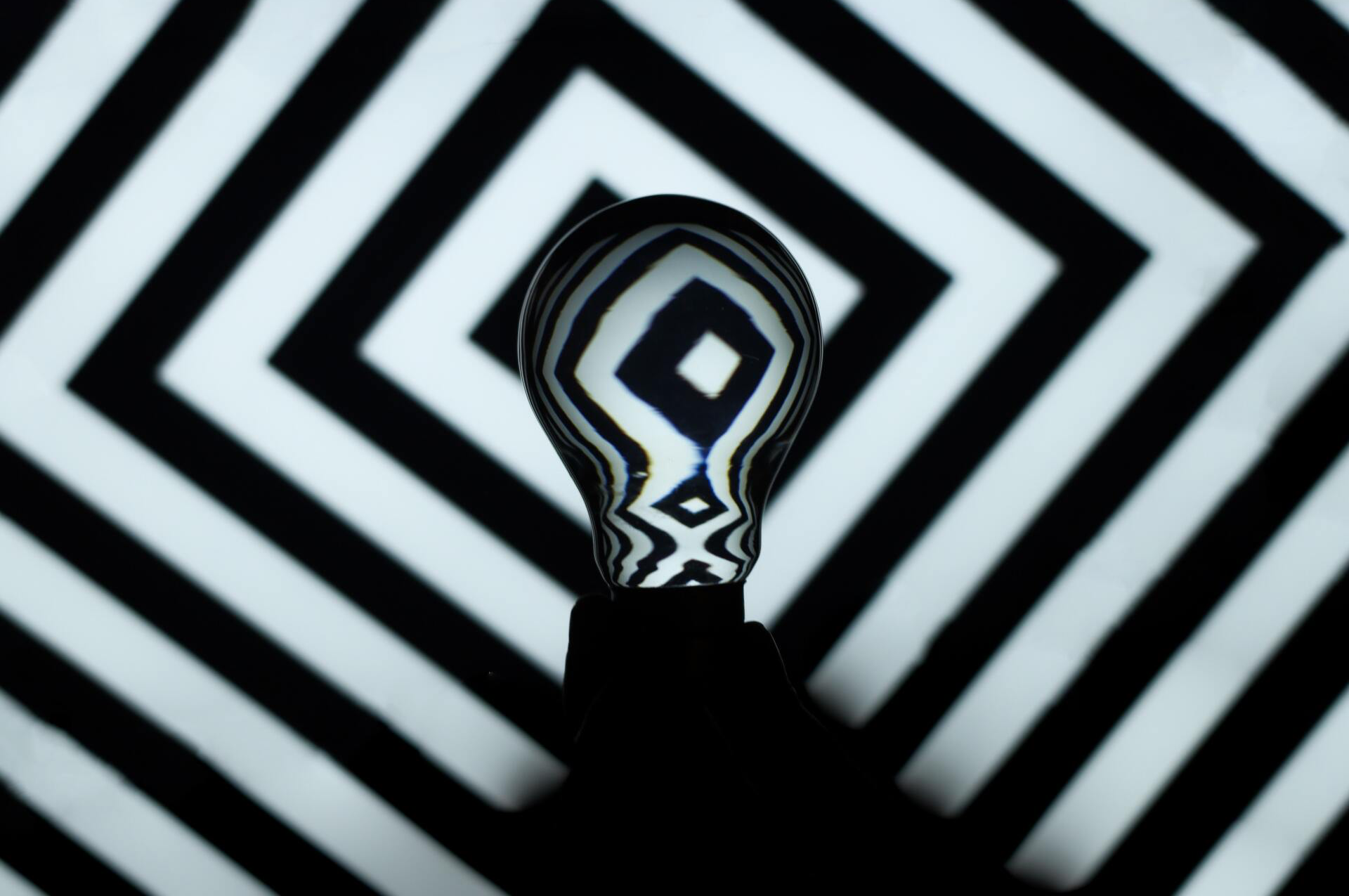Black lines repeating pattern with lightbulb