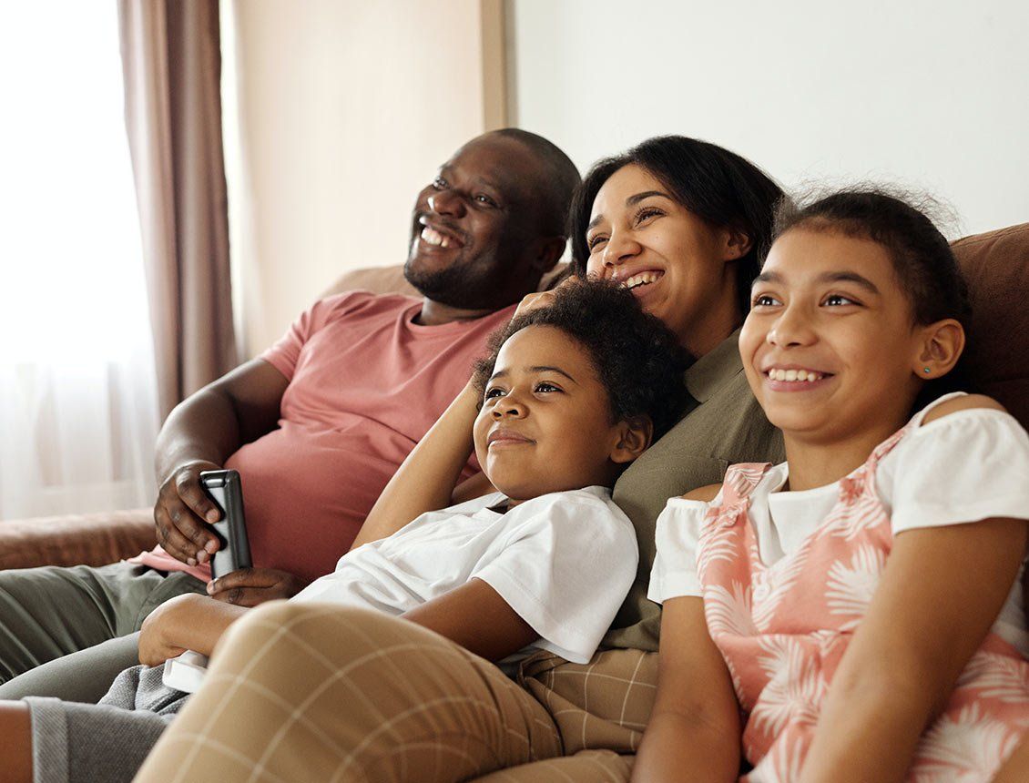 Image of family on couch watching a movie or tv