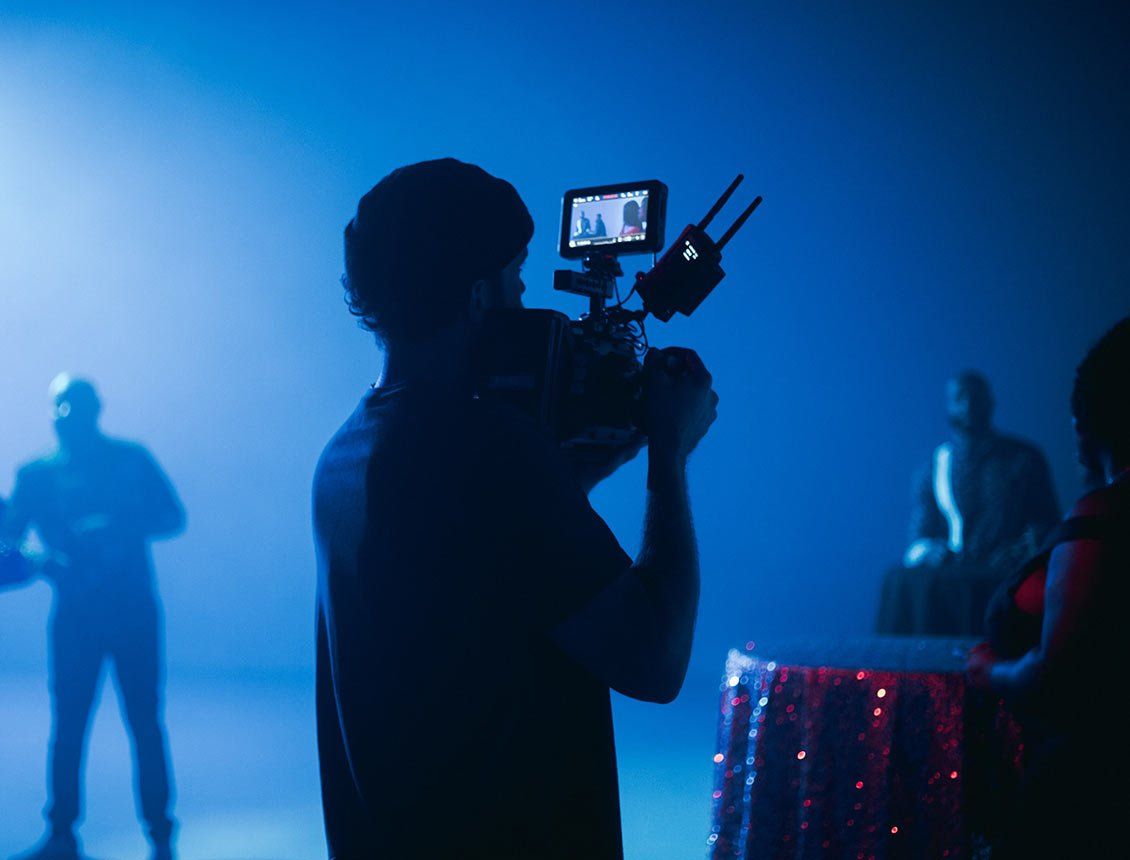 Behind the scenes image of videographer in a studio filming musicians