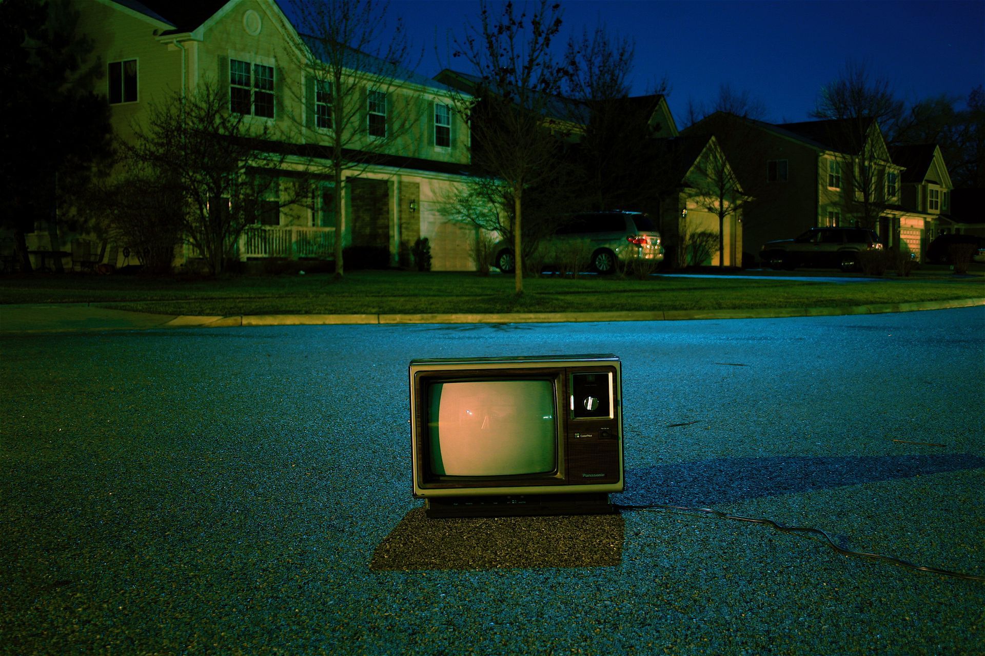 Vintage tv sitting on residential street at night