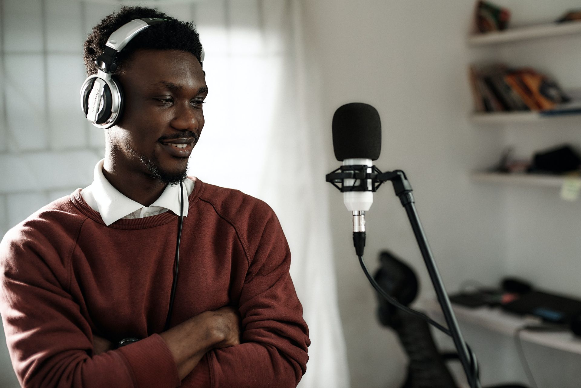 Man wearing headphones in front of vo microphone