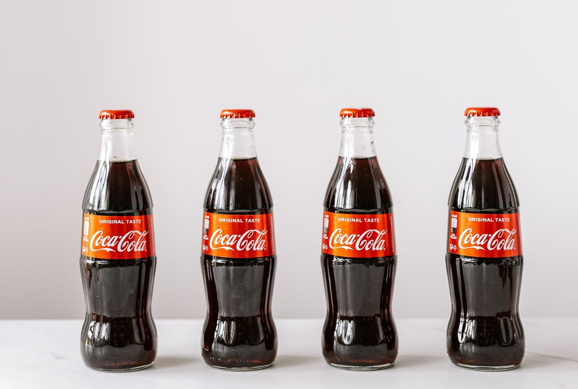 Line of coca cola bottles sitting on countertop