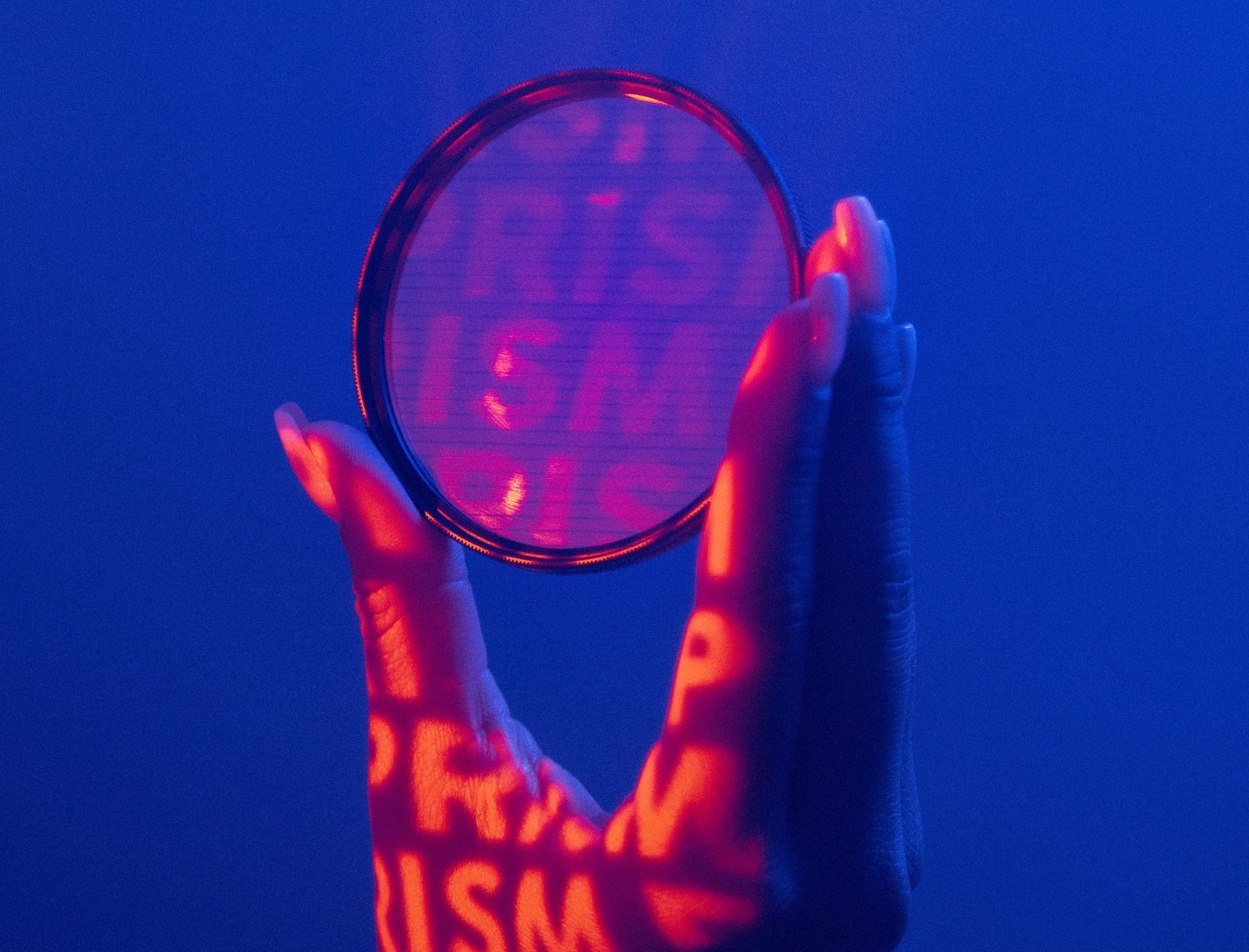 Hand holding lens filter with words prism projected on hand