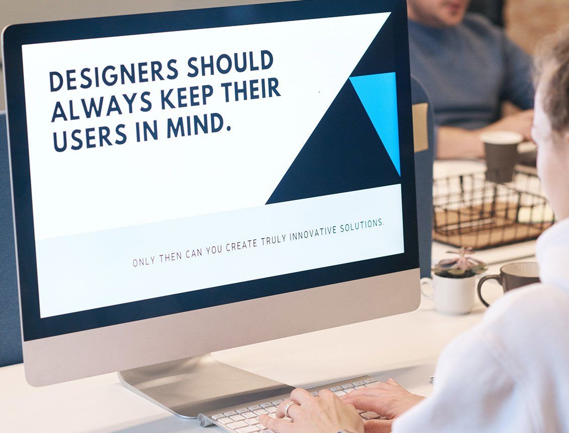 Image of a designer sitting in front of computer screen that says designers should always keep their users in mind