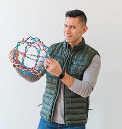 Miguel Cornelio headshot holding expanding sphere colorful toy for Spin Creative team page