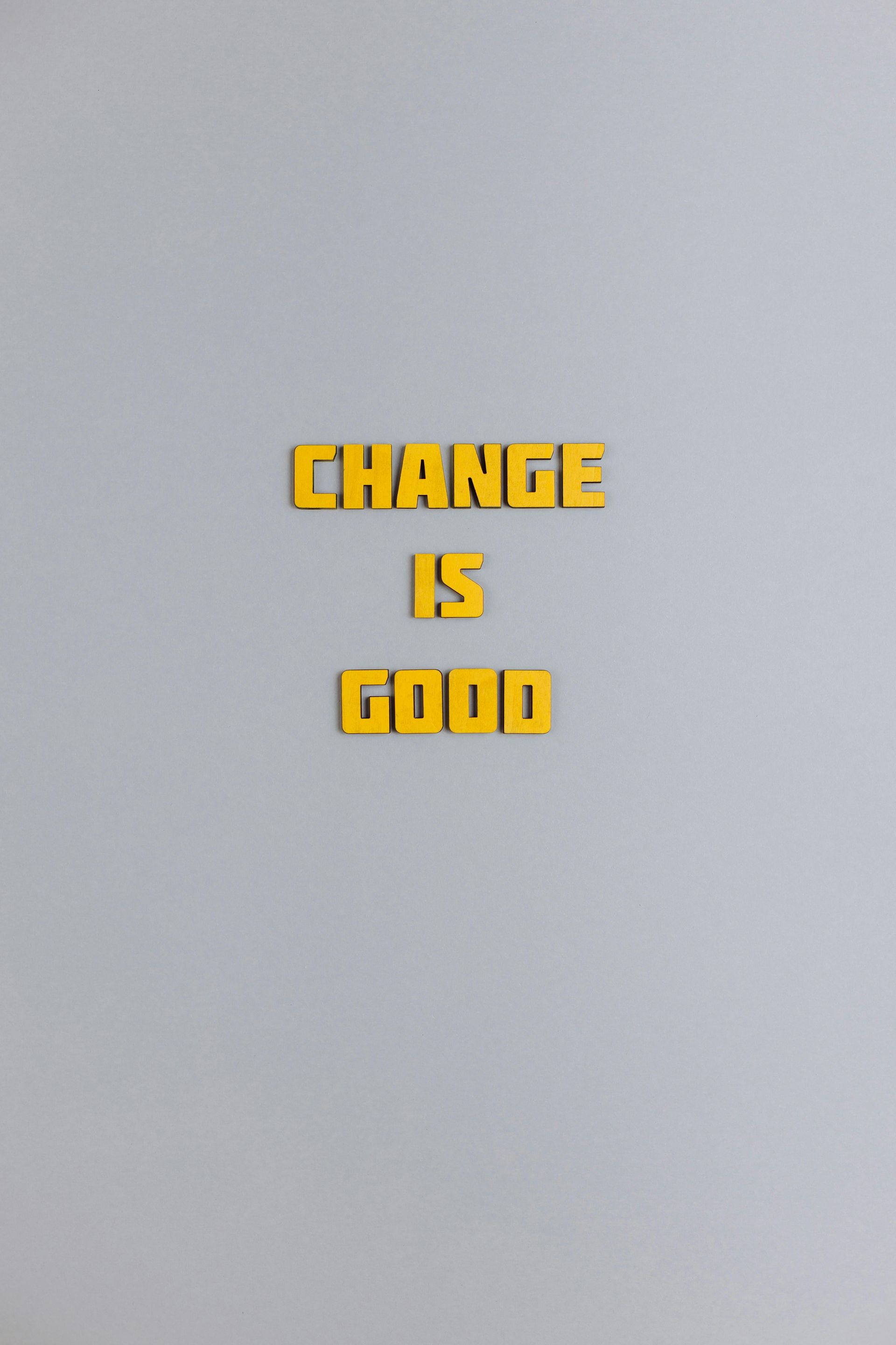 The words change is good are written in yellow letters on a white background.
