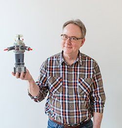 Scott Gwin headshot holding Lost In Space robot for Spin Creative team page