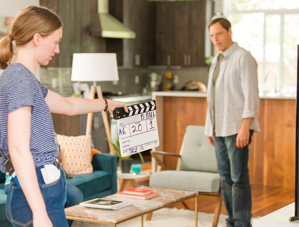 Spin Creative behind the scenes image of a video production shoot in Seattle, showing a production assistant holding a clapboard and actor on set.