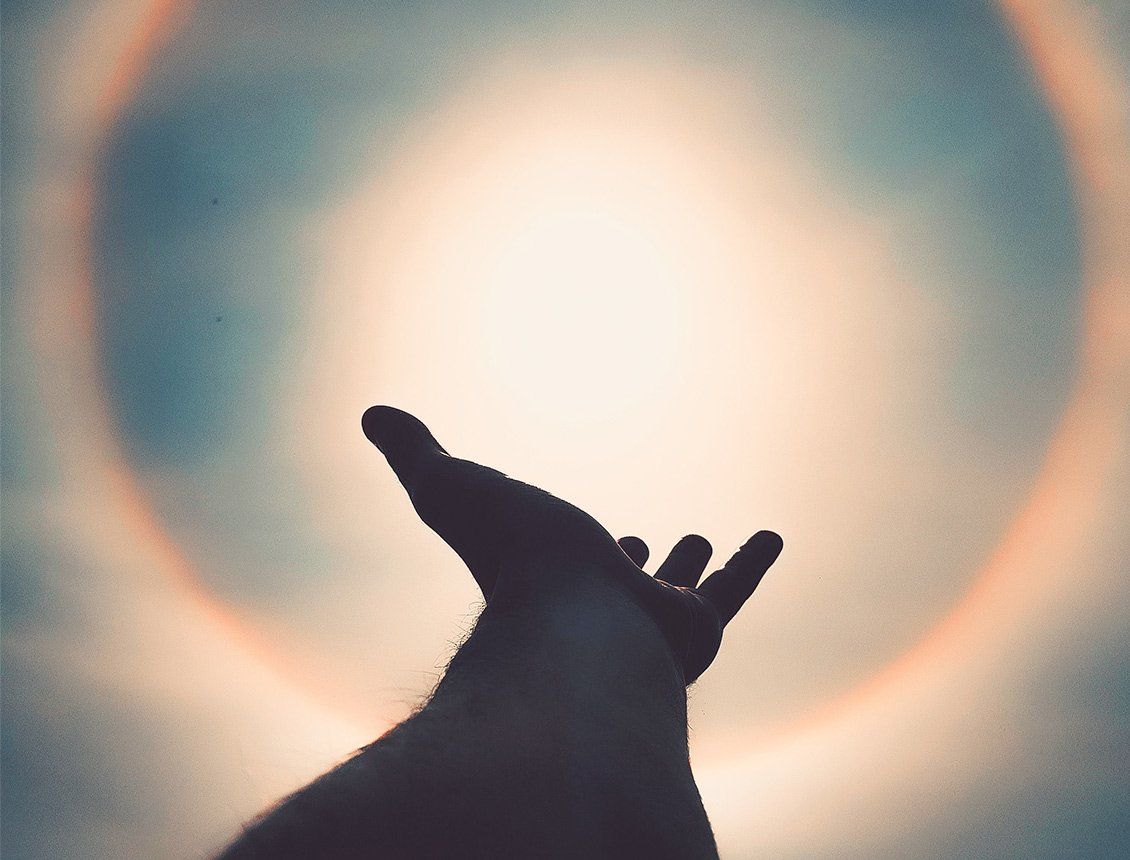 Hand reaching toward the sun.