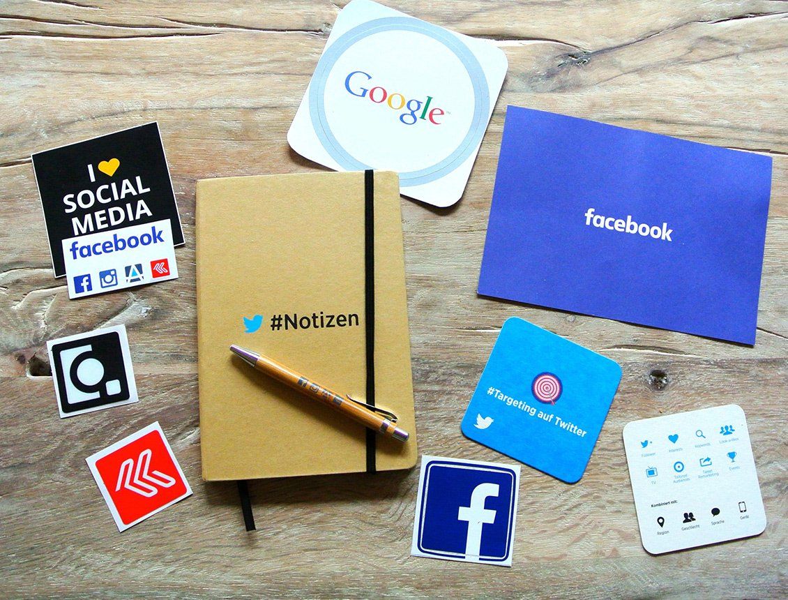Image of social media platforms on a variety of mediums from notebooks to coasters to stickers. 