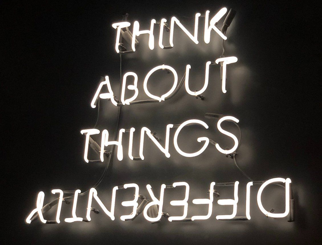 Think about things differently photo of a neon sign used as a way to think about advertising, marketing and video production 