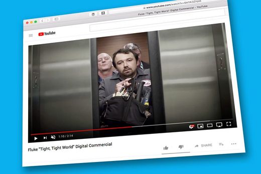 A computer screen shows a video of two men in an elevator.
