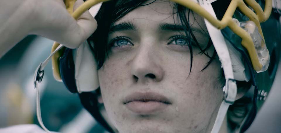 A close up of a person wearing a hockey helmet