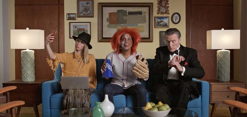 A group of people are sitting on a couch in a living room.