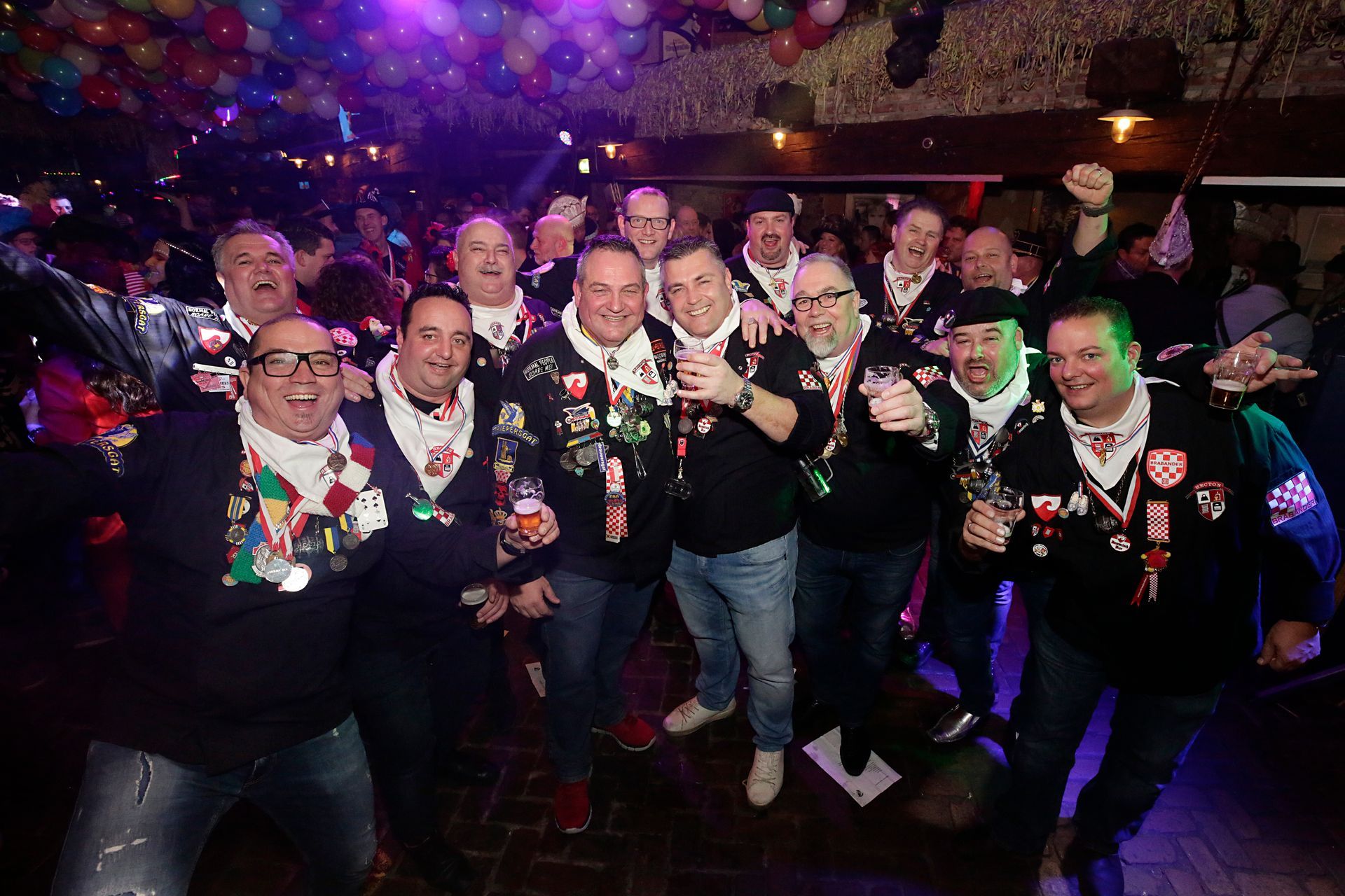 Een groep mannen poseert voor een foto in een club.