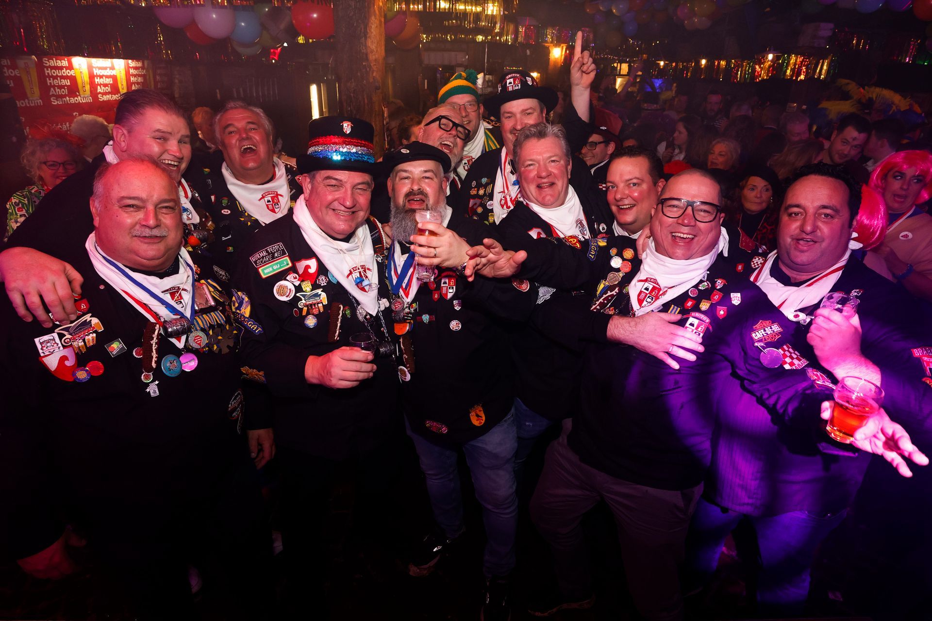 Een groep mannen poseert voor een foto in een donkere kamer