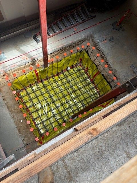 An elevator is going down a tunnel with a light at the end.