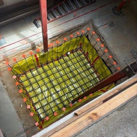 A close up of a concrete pillar with screws attached to it