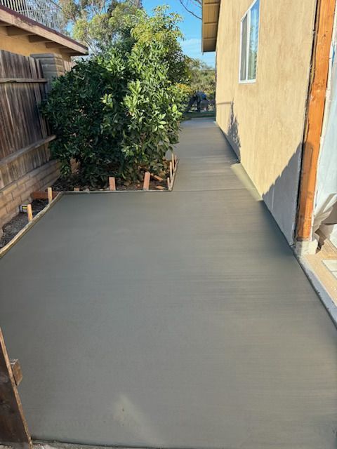 A concrete walkway is being built in front of a house.