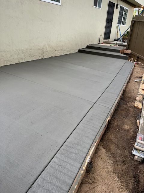A concrete walkway is being built in front of a house.