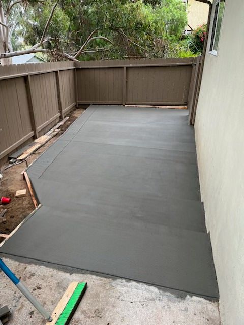 A concrete deck is being built on the side of a house.