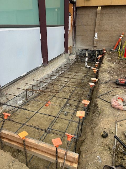 A concrete walkway is being built in front of a building.