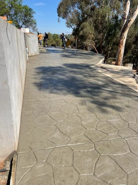A concrete walkway with trees in the background