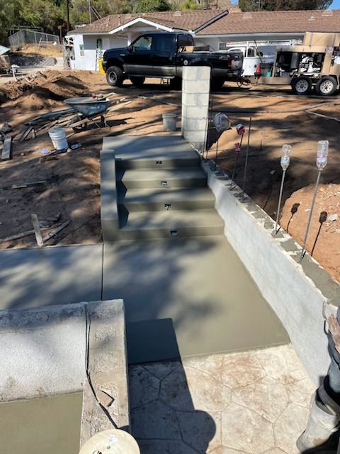 A black truck is parked in front of a house under construction.
