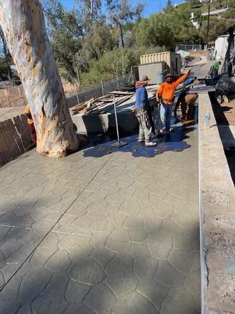 A group of men are working on a concrete walkway