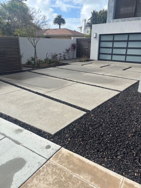 A concrete driveway with a garage door in the background