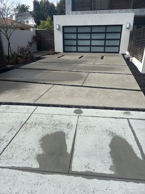 A shadow of a person is cast on the sidewalk in front of a garage door